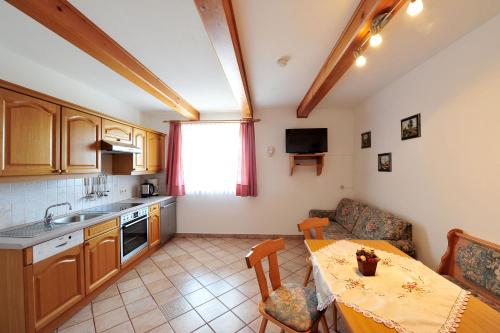 a kitchen with a table and a dining room at Haus Goldeggblick in Goldegg