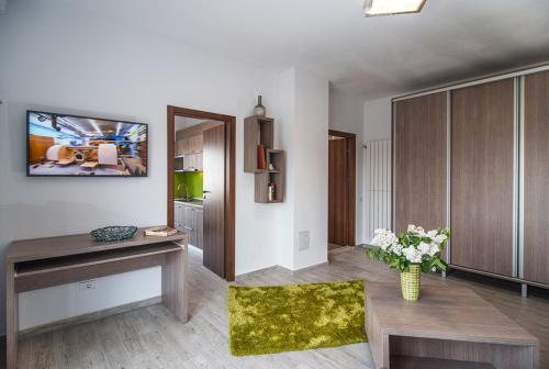 a living room with a table and a vase of flowers at Residence iL Lago in Cluj-Napoca