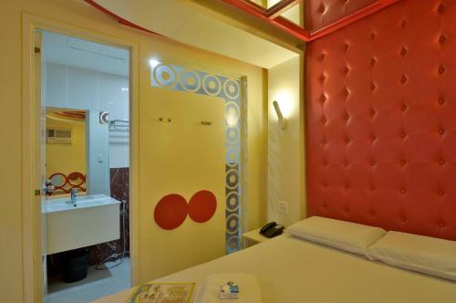 a bedroom with a bed and a mirror and a sink at Hotel 99 Monumento in Manila