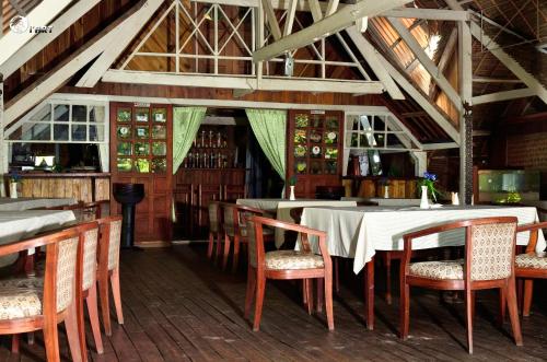 a dining room with tables and chairs in a building at Les Acacias Bungalows in Manambato