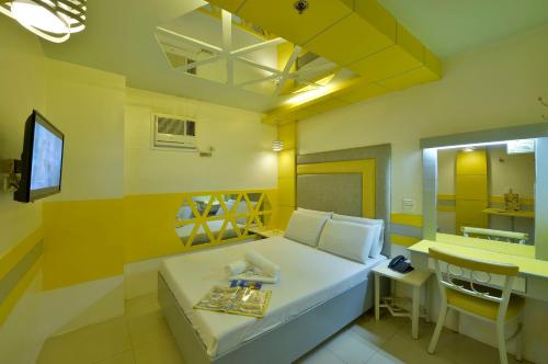 a small room with a bed and a table at Hotel 99 Monumento in Manila