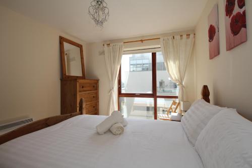 ダブリンにあるNorth Docklands Self Catering apartmentのベッドルーム(白いベッド、ぬいぐるみ付)