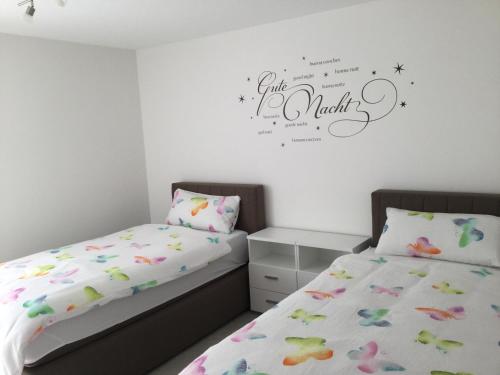 1 dormitorio con 2 camas y un cartel en la pared en Apartment Am Etzelbach, en Balingen