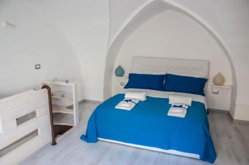 Montesano SalentinoにあるRiz Guest Houseのアーチ型天井のベッドルーム1室(青いベッド1台付)