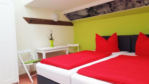ein Schlafzimmer mit roten Kissen und einer grünen Wand in der Unterkunft Radlerhof Spreewald in Kolkwitz