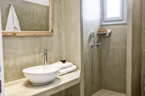 a bathroom with a bowl sink and a shower at Orkos Beach Hotel in Mikri Vigla