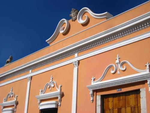 a orange building with a doorway and a blue sky at Hotel Hacienda Mérida VIP in Mérida