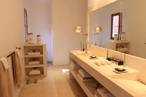 a bathroom with two sinks and a large mirror at Hotel Hacienda Mérida VIP in Mérida