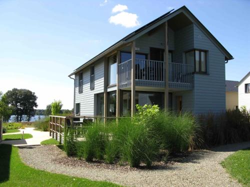a house with a balcony on the side of it at Golden Lakes Village Ardennes in Boussu-lez-Walcourt