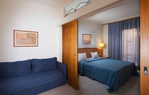 a hotel room with a bed and a couch at Pefkos Beach Studios & Apartments in Pefki