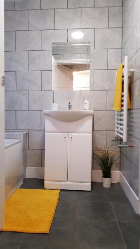 a bathroom with a white sink and a mirror at Fantastic 2 bedroom flat close to King's Cross in London