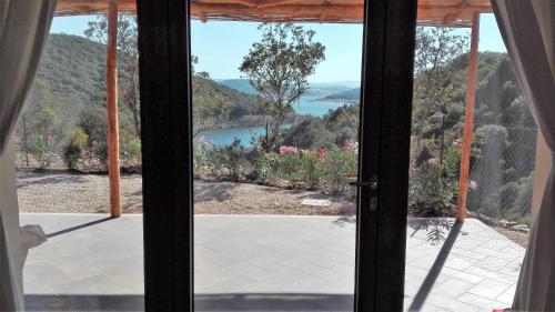 an open door to a view of a lake at Hotel Aldiola Country Resort in Sant Antonio Di Gallura