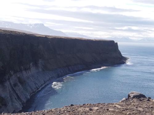 a large cliff next to a body of water at Salthús Guesthouse in Skagaströnd