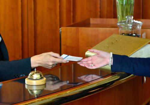 a person is handing another person a credit card at Hotel Der Lindenhof in Gotha