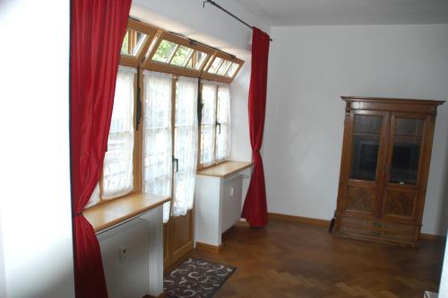Habitación con ventanas y cortina roja. en Kronburger en Oberammergau