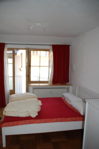 a bedroom with two beds and a red window at Kronburger in Oberammergau