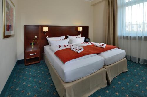 a hotel room with a large bed with towels on it at Hotel Der Lindenhof in Gotha