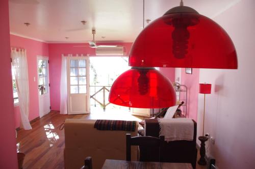 um candeeiro vermelho numa sala de estar com um sofá em Costa Aguacates em Posadas