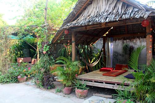 una pequeña casa con un banco en un jardín en Garden Guesthouse, en Kampong Chhnang
