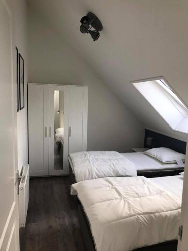 a attic bedroom with two beds and a skylight at De beurs in Hollum
