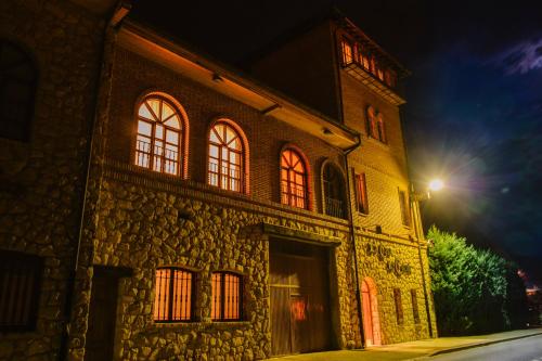 un edificio de piedra con una torre de reloj por la noche en Hotel Vinícola Real-200 Monges, en Albelda de Iregua