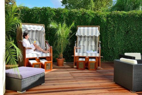 a woman sitting in a chair on a patio at Hotel Der Lindenhof in Gotha