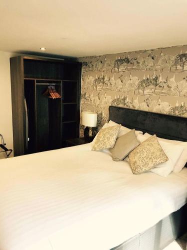 a bedroom with a large white bed with a wall at Slaters Country Inn in Whitmore