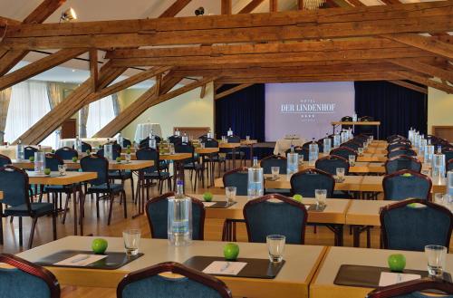 a conference room with tables and chairs and a screen at Hotel Der Lindenhof in Gotha