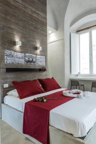 a bedroom with two beds with red pillows at BORGOBELTRANI in Trani