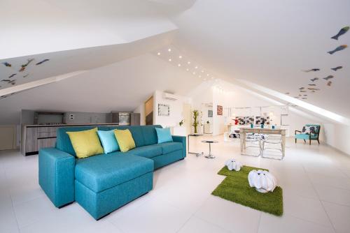 a living room with a blue couch and a kitchen at Fruit Flats by AMALFIVACATION in Minori