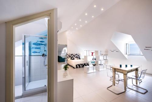 a white living room with a table and a couch at Fruit Flats by AMALFIVACATION in Minori