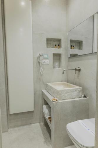 a bathroom with a sink and a toilet and a mirror at BORGOBELTRANI in Trani