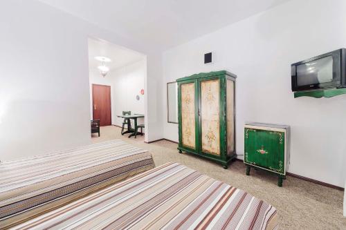 a bedroom with two beds and a flat screen tv at Hotel Tannenhof in Joinville