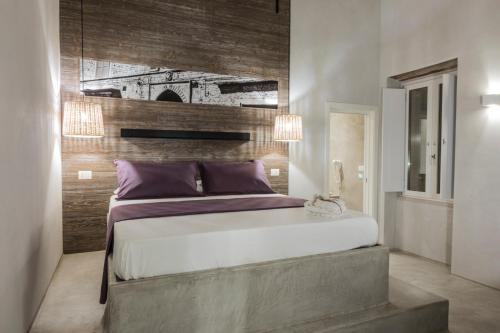 a bedroom with a large bed with a wooden wall at BORGOBELTRANI in Trani