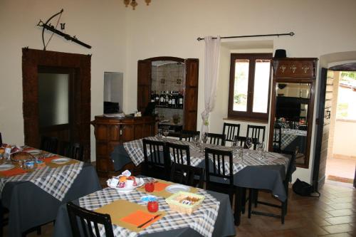 a dining room with tables and chairs and a kitchen at Valle del Belvedere in Spoleto