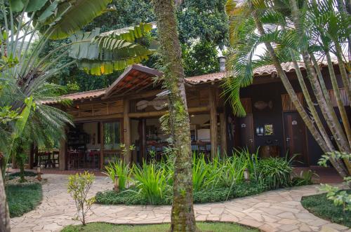 a resort with palm trees in front of it at Pousada Bico Verde in Juquei