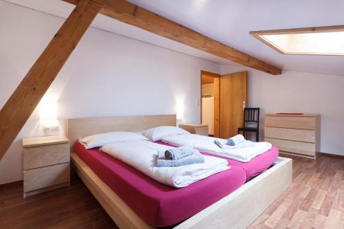 two beds in a large room with wooden ceilings at Haus Angelika in Vandans