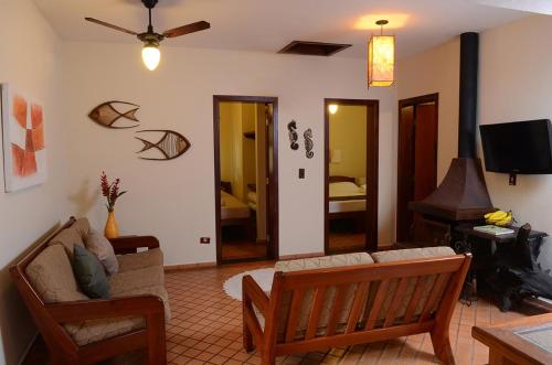 a living room with a couch and a tv at Pousada Bico Verde in Juquei