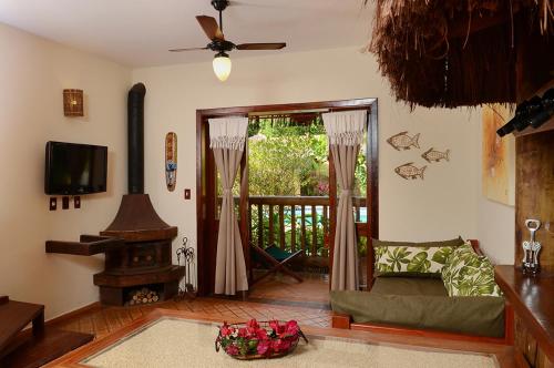 a living room with a couch and a television at Pousada Bico Verde in Juquei