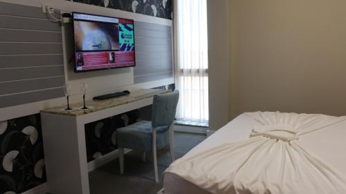 a bedroom with a bed and a tv on a wall at Hotel Admiral in Prizren
