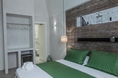 a bedroom with a bed with green pillows and a fireplace at BORGOBELTRANI in Trani