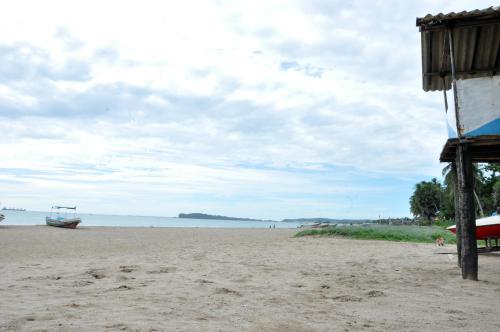 a beach with a boat in the distance at Natraj Guest House in Trincomalee