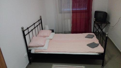 sypialnia z łóżkiem z różowymi kocami i oknem w obiekcie M0 Lakihegy Horgony u 10 w mieście Szigetszentmiklós