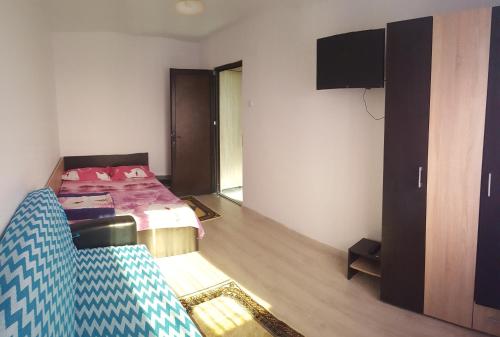 a room with a bed and a couch and a television at Apartament Lupu - Eforie Nord in Eforie Nord