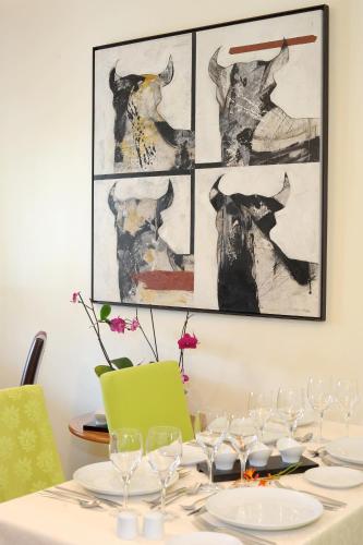 a table with wine glasses on it with art on the wall at Quinta Da Cova Do Milho in Santo António da Serra