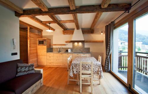 a kitchen and dining room with a table and a couch at Chalet Teo e Marianna in Bormio