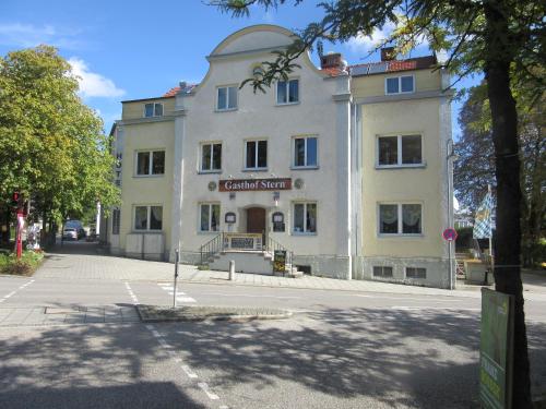 un grand bâtiment blanc sur le côté d'une rue dans l'établissement Hotel Stern, à Gersthofen