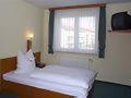 a room with a white bed and a window at Hotel am Platz in Hohenmölsen