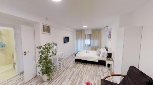 a white room with a bed and a window at Sun Villa Residence in Bucharest