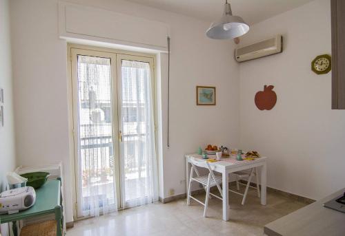 una cucina con tavolo e una finestra con una mela sul muro di A casa di Lia a Siracusa